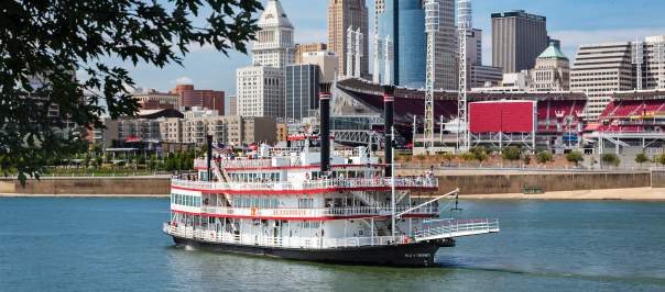 photo of a paddlewheel riverboat from bb riverboats in newport kentucky with the cincinnati oh skyline in the background