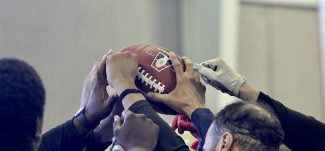 Team members touch a football.