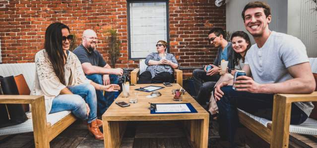 group of adults having cocktails at rooftop bar