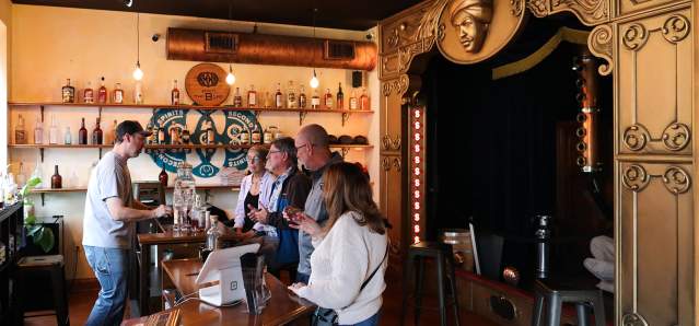 A group of people sample spirits at a tour of Second Sight Spirits.