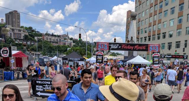 A group of people are wandering downtown Cincinnati during the Taste of Cincinnati festivals