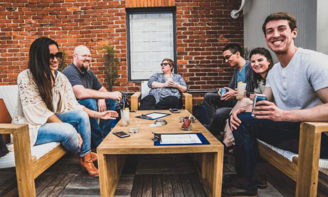 group of adults having cocktails at rooftop bar