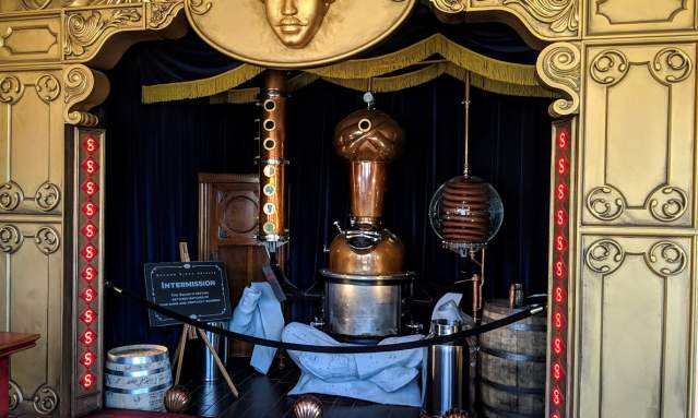 A still shaped like a fortune teller, under a gold theater awning at Second Sight Spirits