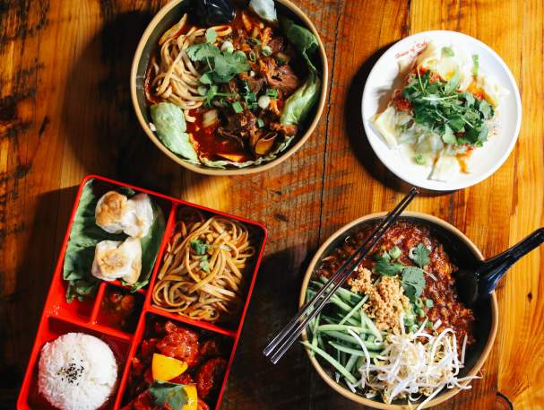 An array of dishes sit on a wooden table.