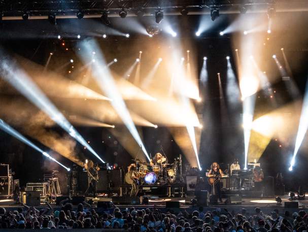 A band is silhouetted against rays of golden light.