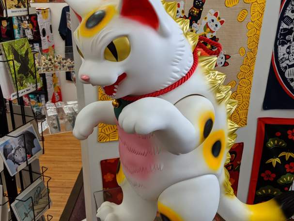 A large white, pink, and gold Lucky Cat statue with a red collar at the Lucky Cat Museum in Cincinnati, Ohio