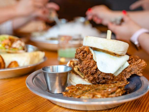 A fried chicken breast on an english muffin, served with hashbrowns from Rich's Proper.