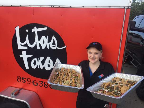 woman holding two trays of tacos in front of lita's taco truck in florence ky