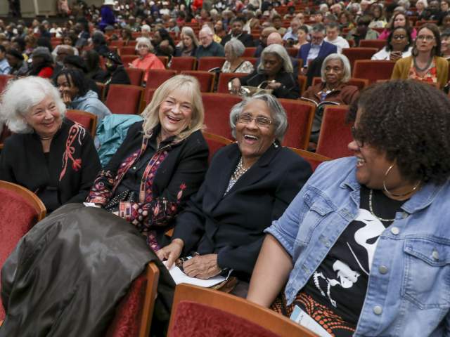 A group of women laugh and talk while seated at a Cincinnati Symphony Orchestra performance.