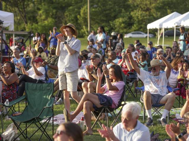 A group of people in lawn chairs applaud for a Cincinnati Symphony Orchestra performance
