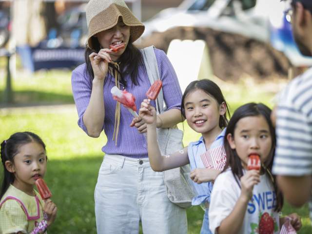 A family eat popsicles during one of the Brady Block Parties.
