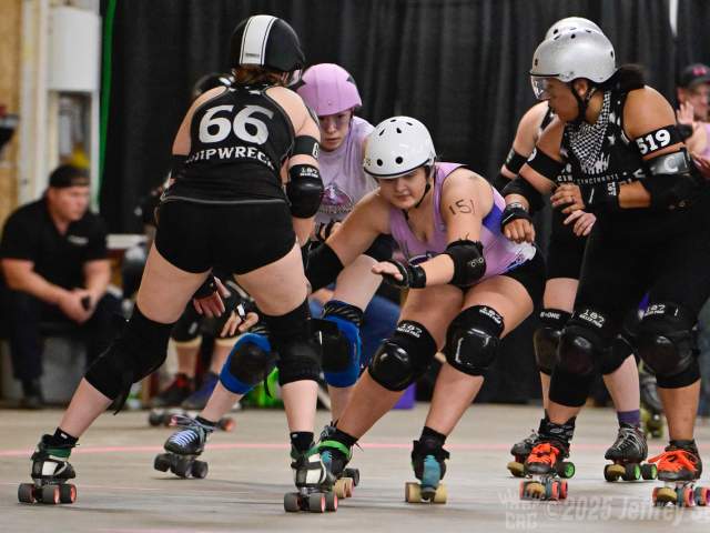 Two skaters in black uniforms flank two skaters in lavender uniforms.