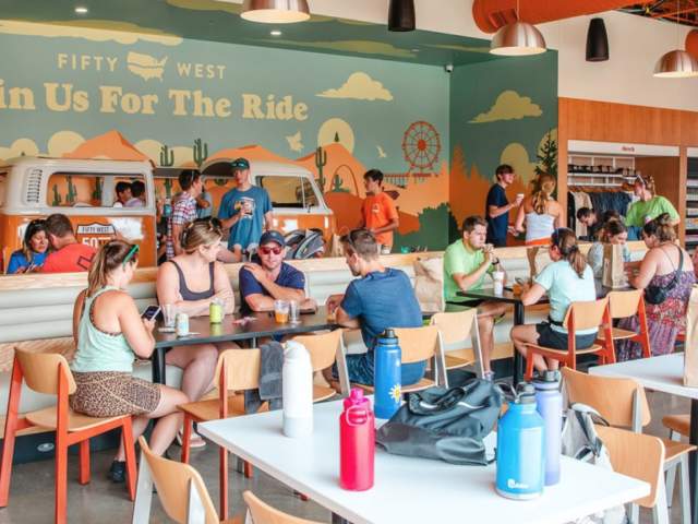 People sit in a dining area in groups.
