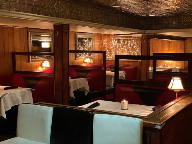 An ambient-lit dining room with tables featuring white linens