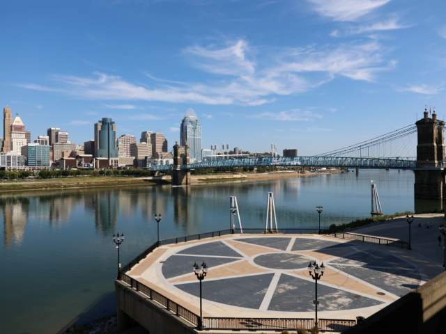 A gathering place in Covington, Ky along the Ohio River with a scenic backdrop of the Cincinnati Skyline and Roebling Bridge.