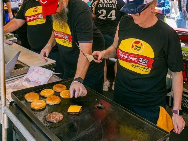 A crew at Taste of Cincinnati grill up some cheeseburgers.