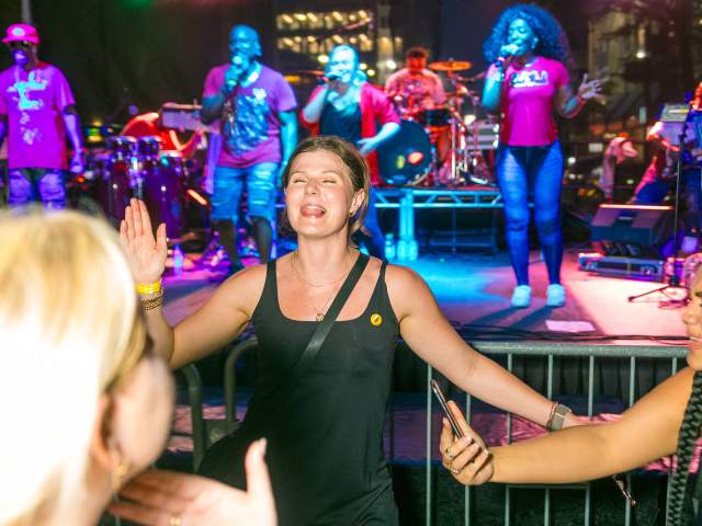 An energetic crowd dances to live music at Taste of Cincinnati