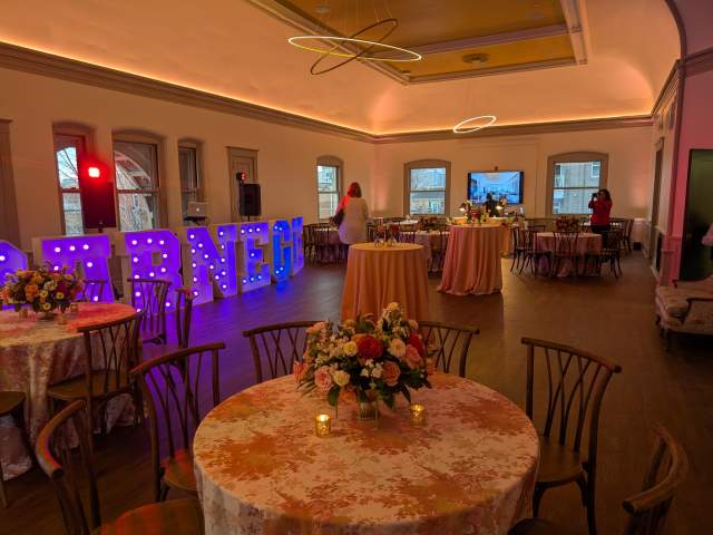 The upstairs event space at Carnegie Hall Event Center in Newport, Ky., with round tables and floral arrangements.