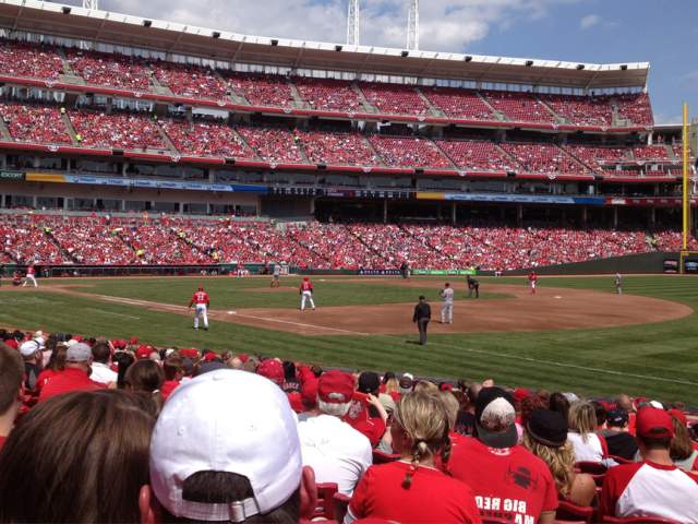 Cincinnati Reds fans in red shirts watch the baseball team play in Great American Ball Park