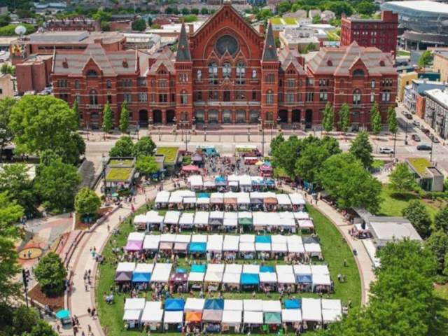 Image is an arial view of the City Flea Market with the Cincinnati Music Hall in the background.