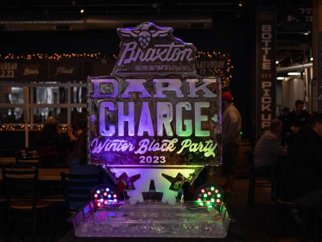 A ice sculpture lit up with purple, green, and yellow lights.