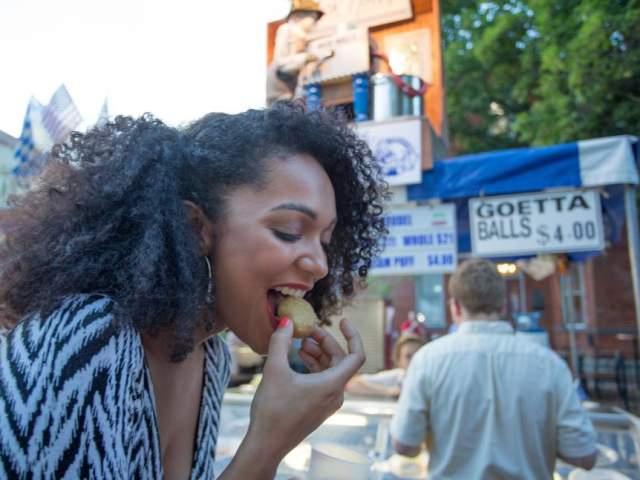 Woman eating goetta balls at a street festival (photo: CincinnatiUSA.com)