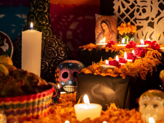 Image is of candles and Mexican day of the dead skulls.