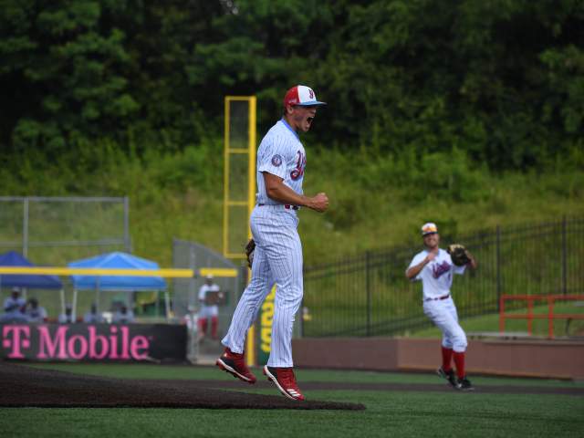 Image is of a pitcher jumping up with a big smile on his face.