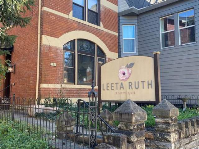 A red brick building with a sign out front that says Leeta Ruth