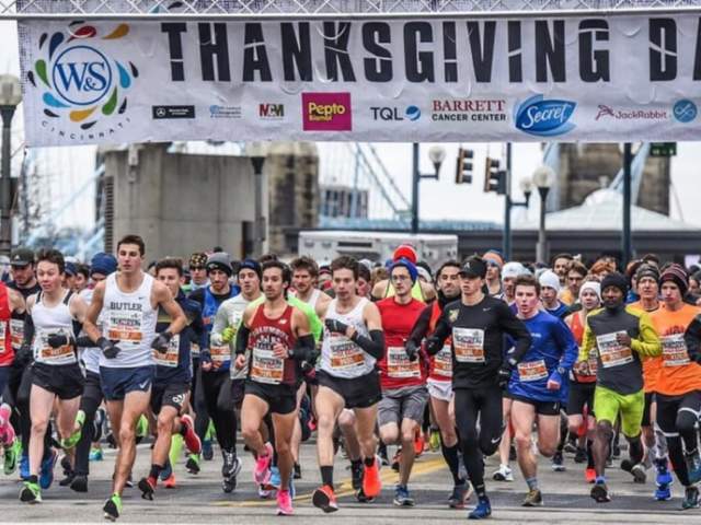 Image is of a bunch of runners, running from the starting line.