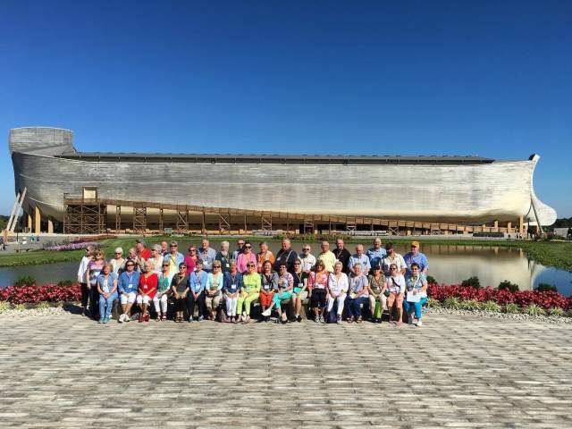 A travel group poses in front of the Ark Encounter.