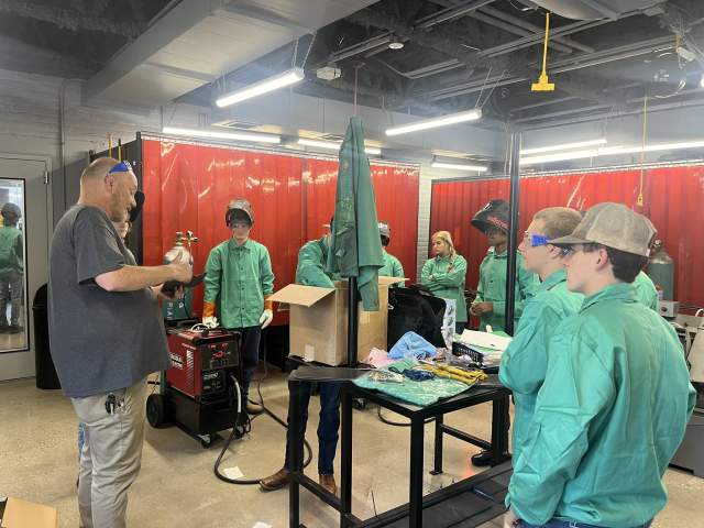 A group of students listen to a presentation on welding at Gateway.
