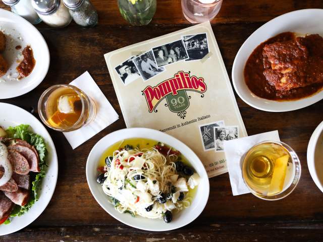 An overhead view of Pompilio's menu surrounded by dishes and cocktails.