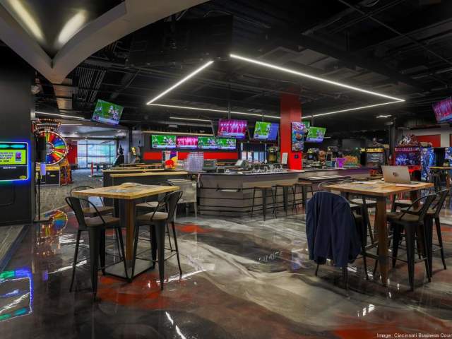 Interior of Velocity Esports showing arcade machines along the back and several tables for sitting.