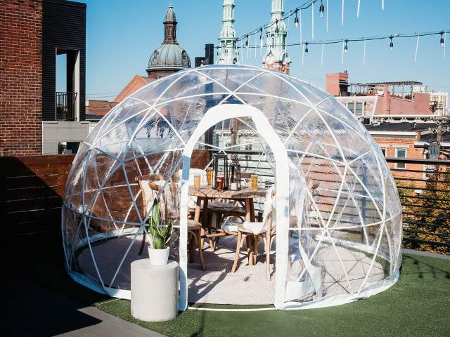 Daytime photo of clear plastic igloo on the rooftop of Braxton Brewing.