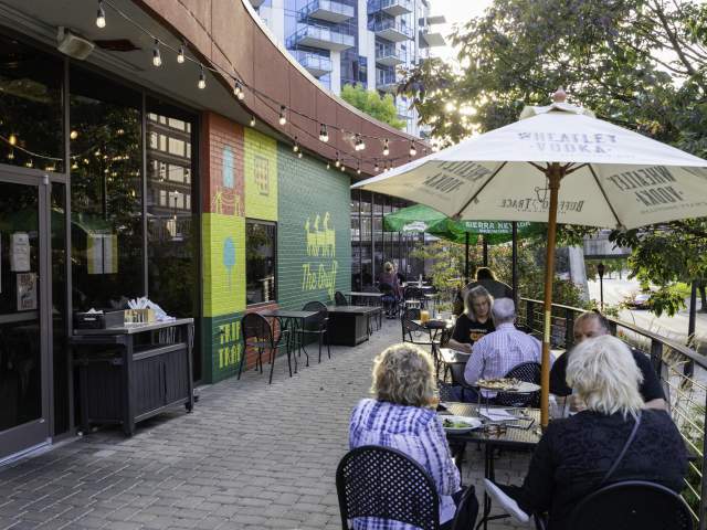 Image is of diners sitting on a patio in the front of The Gruff.