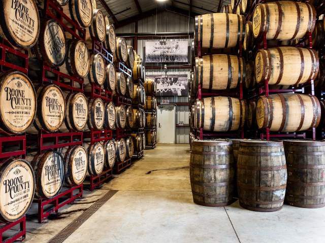 Stacks of bourbon barrels held in red shelves at Boone County Distilling Co.