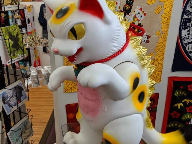 A large white, pink, and gold Lucky Cat statue with a red collar at the Lucky Cat Museum in Cincinnati, Ohio