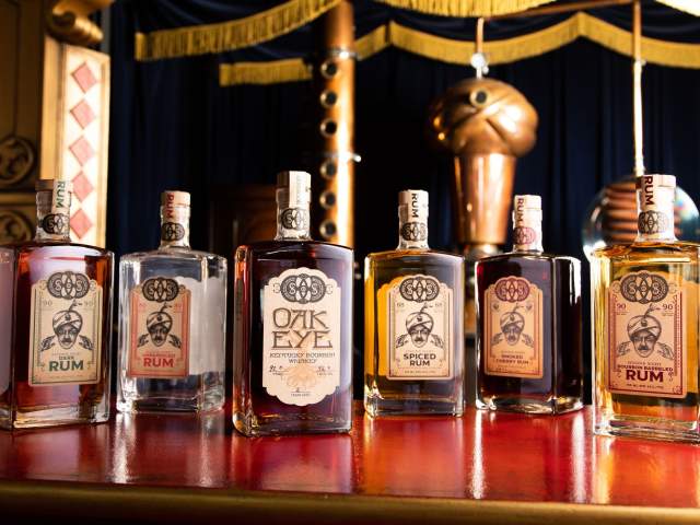A line of six bottles, one each of the different spirits Second Sight Spirits makes.