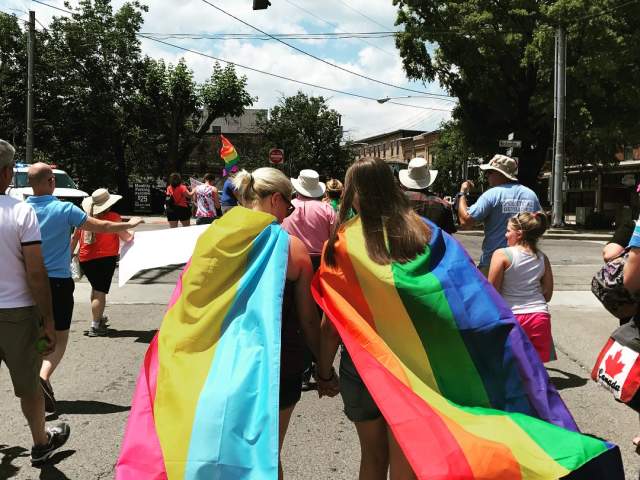 Two young people wearing Pride flags at NKY Pride in Covington Kentucky