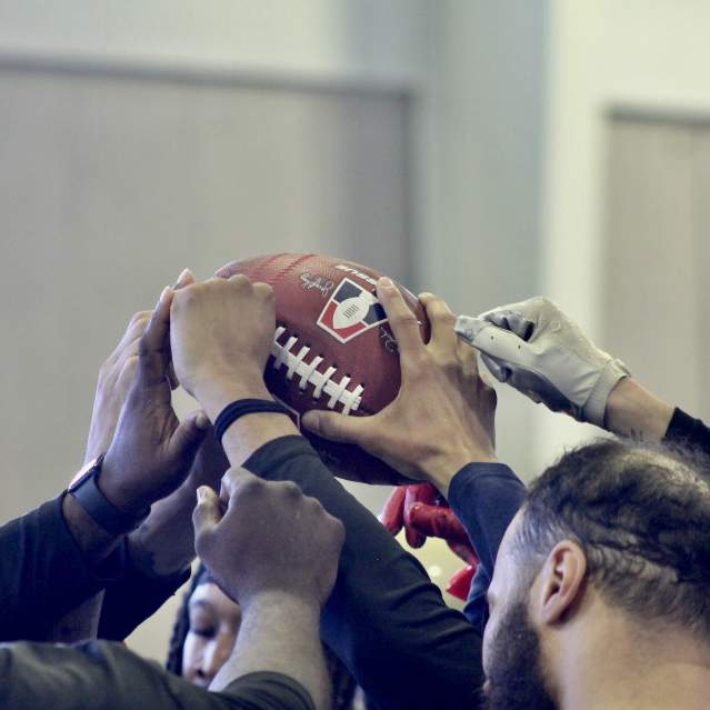Team members touch a football.