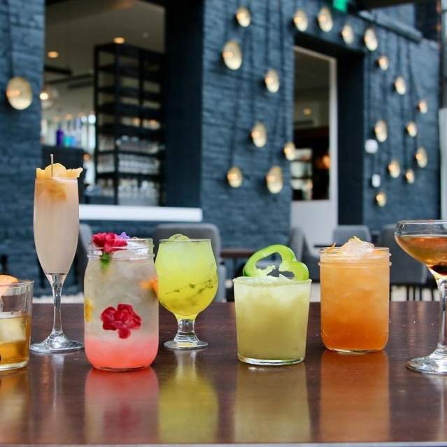 A row of various cocktails, colored pink, yellow, amber and green at Coppin's Restaurant in Covington, Ky.