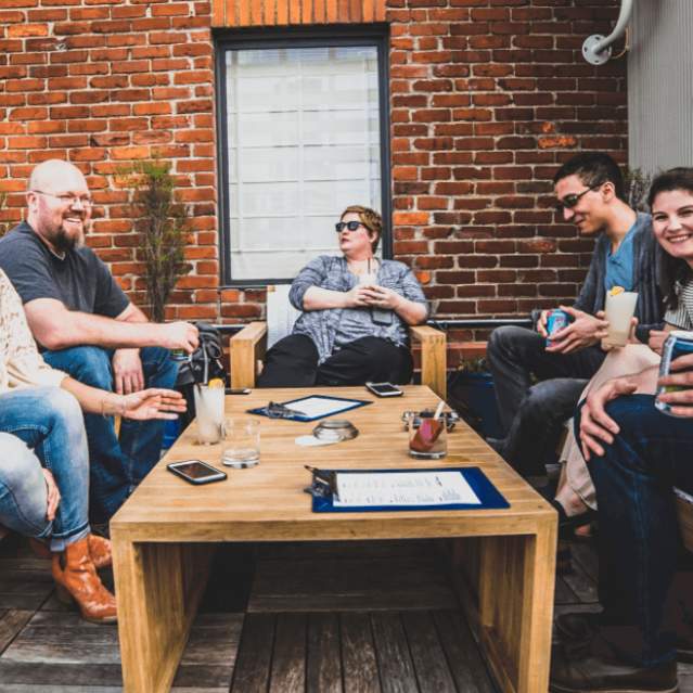 group of adults having cocktails at rooftop bar