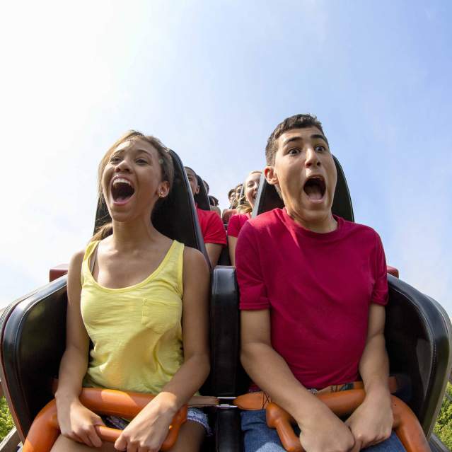 young couple having fun riding a roller coast in Cincinnati