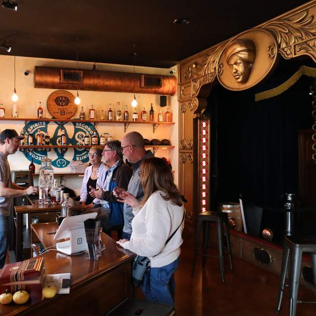 A group of people sample spirits at a tour of Second Sight Spirits.