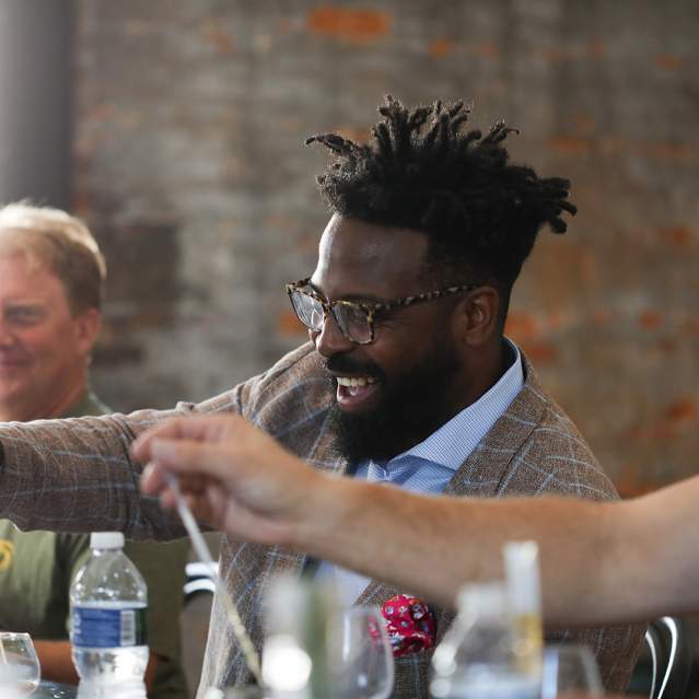 3 men laughing and tasting bourbon