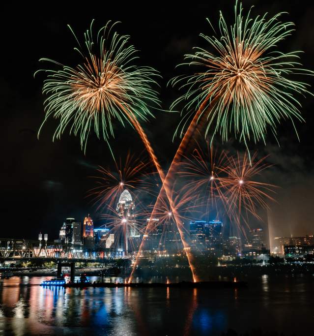 Gold and green fireworks burst in the sky high above the Cincinnati skyline