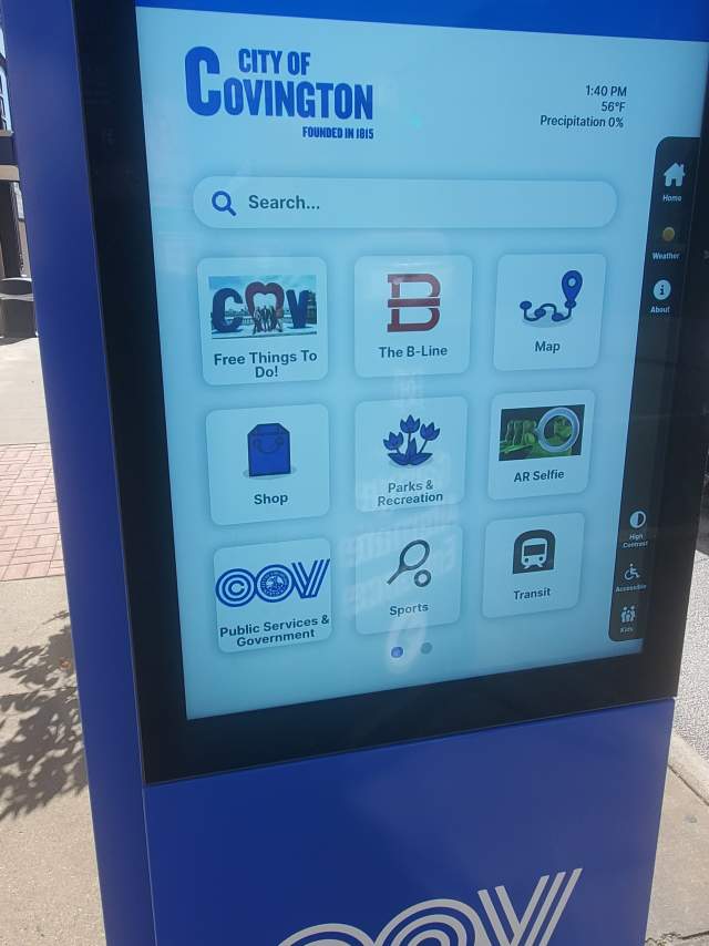 A large blue sign features a touchscreen with navigation apps to help explore Covington, Kentucky