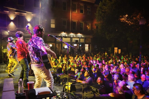 Outdoor concert at Braxton Brewing Company with band playing on stage and crowd of people listening in covington kentucky