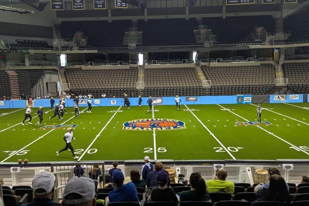An arena football team practices at an indoor space.
